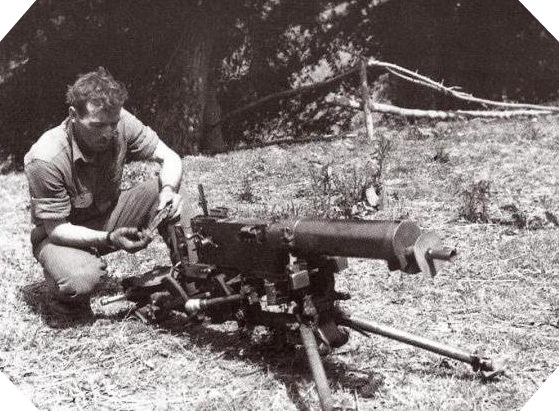Pendant la bataille de Normandie, le soldat de première classe Arland "Pappy" Fry, spécialiste des armements appartenant à la compagnie A du 377th Parachute Field Artillery Battalion inspecte une mitrailleuse MG 08 sur trépied abandonnée par les Allemands dans la commune de Catz située à l'est de Carentan dans la Manche