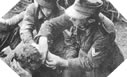 Image : Deux caporaux-chefs Allemands soignent un parachutiste Allemand près de Ranville