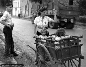 Un convoi américain circule sur l'avenue Quakenbruck devant une famille d'Alençon. Photo : US National Archives