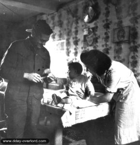 27 juin 1944 : le capitaine Earl Bourbonnais du 23rd Field Ambulance Corps de l’armée canadienne vaccine Nicole Pierre à Basly. Photo : US National Archives