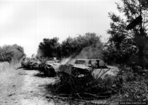 Mi-août 1944 : des épaves encore fumantes de véhicules de transport de troupe allemands dans le secteur de Carrouges, sur la route de Rânes, détruits par les chasseurs P-47 Thunderbolt du 404th Fighter Group qui est alors basé sur l’aérodrome ALG A-12 de Lignerolles. Photo : US National Archives