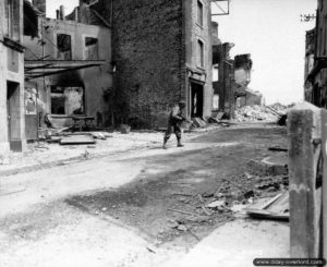 13 juin 1944 : une patrouille de la compagnie F du 26ème régiment de la 1ère division d’infanterie américaine progresse rue de Chanzy vers 09h00. Photo : US National Archives