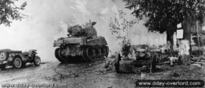Un char M4 Sherman américain progresse dans la ville de Dreux pendant les combats de la libération en passant à proximité d’une Jeep et d’un canon antichar allemand Pak 40 abandonné. Photo : US National Archives