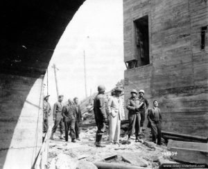 10 août 1944 : des militaires américains et des civils inspectent le site de lancement de V1 Wasserwerk N°2 au lieu-dit Brécourt sur la commune d’Equeurdreville-Hainneville. Photo : US National Archives