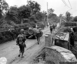 23 juillet 1944 : une colonne de la 4ème division d'infanterie américaine progresse au Hommet d'Arthenay au lieu dit La Maison Basset, sous les yeux des habitants. Photo : US National Archives