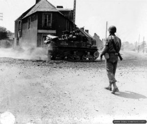 Un policier militaire américain armé d’une carabine USM1 observe un char léger Stuart poursuivre sa progression dans le Tronquay. Photo : US National Archives