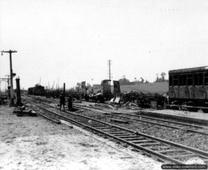 17 juin 1944 : les vestiges d’un train bombardé encombrent la gare. Photo : US National Archives