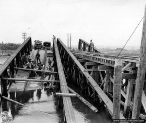 2 août 1944 : des sapeurs américains installent un tablier en bois visant à remplacer le pont métallique détruit afin de franchir la Vire à Montmartin-en-Graignes. Photo : US National Archives