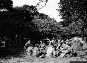 22 juillet 1944 : des soldats américains prennent leur repas dans leur bivouac au milieu d’un verger, dans le secteur de Négreville. Photo : US National Archives