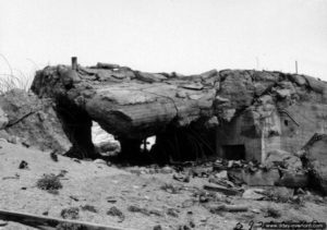 Une des quatre casemates type Regelbau M 272 de la batterie Blankenese en ruine suite au dynamitage réalisé lors d’essais par le génie américain à Néville-sur-Mer. Photo : US National Archives