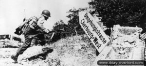 Un soldat américain appartenant à la 9ème division se met à couvert après avoir traversé la route de Nouainville. Photo : US National Archives