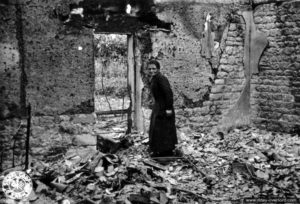 17 juin 1944 : une habitante d’Orglandes dans les vestiges de sa maison détruite par les bombardements. Photo : US National Archives
