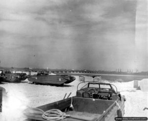 Des caissons Phoenix et des éléments Whales devant être utilisés dans le cadre de la construction des ports artificiels en Normandie sont stockés devant Selsey en même temps que des véhicules de transport amphibies DUKW. Photo : US National Archives