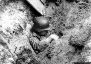 Un soldat allemand, enseveli par les projections de terre suite à un bombardement américain, tente de s’extraire à la force des bras. Photo : US National Archives