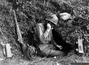 11 août 1944 : le lieutenant Thompson appartenant au 117ème régiment d’infanterie, 30ème division d’infanterie américaine, reçoit ses ordres à la radio depuis son trou de combat dans le secteur de Saint-Barthélémy. Photo : US National Archives