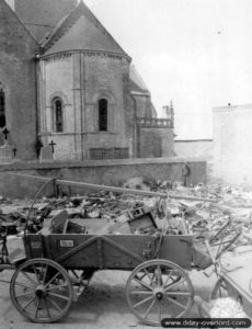 Un attelage et du matériel divers abandonné par les Allemands devant l’église de Sainte-Côme-du-Mont. Photo : US National Archives