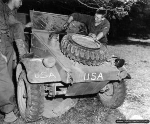 9 août 1944 : à Saint-Manvieu-Bocage le sergent Hunt appartenant à la 28ème division d’infanterie ajoute des marquages américains à une Kübelwagen récupérée aux Allemands. Photo : US National Archives