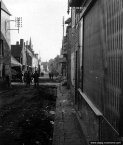 5 août 1944 : des soldats américains du 22nd Infantry Regiment, 4th Infantry Division, progressent dans une rue de Saint-Pois. Photo : US National Archives