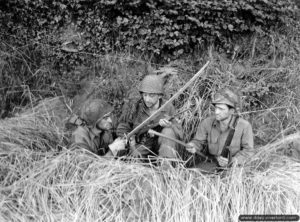 13 août 1944 : dans le secteur de Sourdeval le soldat Di Costa et les soldats de première classe Goldstein et Gagliardi appartenant à la 28ème division d’infanterie observent un sabre de cavalerie française dans un trou de combat. Photo : US National Archives
