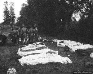 Corps de soldats étendus sur le sol dans le cimetière provisoire de Blosville. Photo : US National Archives