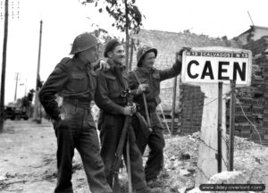 9 juillet 1944 : les soldats Bernard Hoo, John MacCouville et J. R. Kostick appartenant au Queen’s Own Rifles of Canada, 8th Brigade, 3rd Canadian Infantry Division, devant le panneau de l’entrée ouest de Caen. Photo : US National Archives