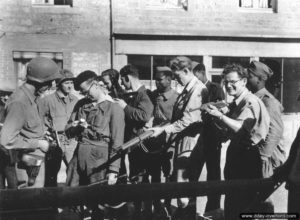 14 août 1944 : des soldats américains et des résistants français de Couterne observent l’armement de chacun. Photo : US National Archives
