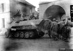 A Fel, des auxiliaires sanitaires américains du Regimental Medical Detachment du 359ème régiment de la 90ème division d’infanterie prennent en charge des blessés allemands à bord d’un SdKfz 250 pris à l’ennemi. Photo : US National Archives