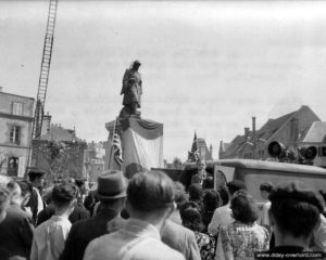 4 août 1944 : un speaker au micro d’un Dodge WC 54 Ambulance donne des informations à la population locale au pied du monument aux Morts de Granville. Photo : US National Archives