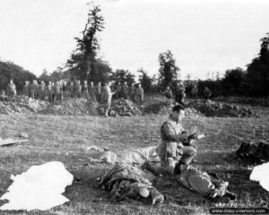 L’aumônier américain Francis L. Sampson du 501st PIR de la 101ème division aéroportée bénit les corps de parachutistes à Hiesville. Photo : US National Archives