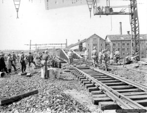 Mise en place d’une ligne ferroviaire sur un pont Bailey par le 332nd Engineer General Service Regiment au Mans. Photo : US National Archives