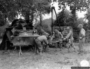 16 août 1944 : changement du pont avant d’un véhicule M8 Greyhound posé sur chandelles. Photo : US National Archives