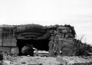 Une des quatre casemates type Regelbau M 272 de la batterie Blankenese en ruine suite au dynamitage réalisé lors d’essais par le génie américain à Néville-sur-Mer. Photo : US National Archives