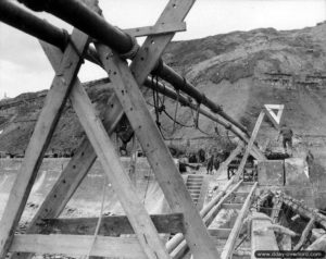 Le départ du pipeline situé au niveau du môle ouest de Port-en-Bessin (un tuyau essence, un tuyau gazoil), permettant le ravitaillement des troupes dans le cadre de l'opération PLUTO ("minor system"). Photo : US National Archives