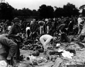 23 juillet 1944 : le ravitaillement en nouveaux équipements et uniforme est arrivé et les soldats américains de la 90th Infantry Division en profitent pour changer leur tenue dans le secteur de Prétot-Sainte-Suzanne, deux jours avant le lancement de l’opération Cobra dans la Manche. Photo : US National Archives