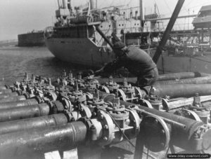 24 juillet 1944 : l’Empire Traveller livre ses 9 000 tonnes de carburant à partir de la digue de Querqueville. Des militaires de la de la 87th Engineer Petroleum Distribution Company appuient la livraison. Photo : US National Archives