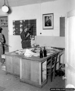 21 juin 1944 : le soldat John Walters de la police militaire américaine dans un bureau utilisé par l’administration allemande à Saint-Clair-sur-l’Elle. Photo : US National Archives