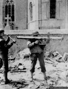 Un officier américain s’exerce au système de visée d’un lance-roquettes Panzerschreck pris aux Allemands à Sainte-Côme-du-Mont. Photo : US National Archives