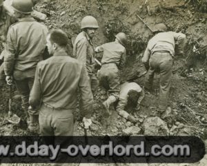 24 juillet 1944 : des soldats américains du 117ème régiment de la 30ème division d’infanterie enterrés vivants par les gerbes de terre projetées suite au bombardement allié dans le secteur de Saint-Gilles (opération Cobra). Photo : US National Archives