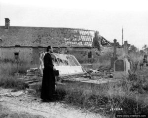7 juillet 1944 : l’abbé Lecourtois, curé de Saint-Jores, observe les dégâts des bombardements. Photo : US National Archives