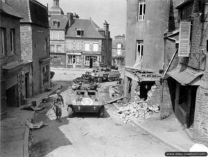 Des véhicules de reconnaissance M8 Greyhound appartenant au 82nd Armored Reconnaissance Battalion, Combat Command A, 2nd Armored Division dans les rues de Saint-Sever. Photo : US National Archives