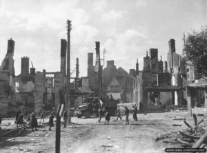 Des soldats de la 28ème division d’infanterie progressent dans les ruines de Sourdeval, rue de Provence (aujourd’hui rue de Verdun). Photo : US National Archives