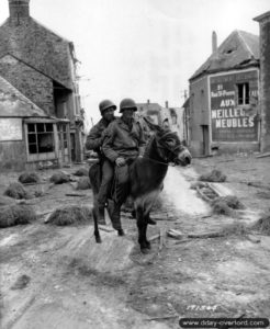 8 juillet 1944 : le première classe William Jackson et le T4 Joseph King appartenant à la 1ère division d’infanterie américaine se déplacent à dos d’âne le long de la route de Caen. Photo : US National Archives