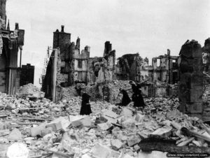 29 juillet 1944 : les chanoines Mignot et Gazengel (respectivement supérieur et directeur du Grand Séminaire) et 2 séminaristes secouristes dans les ruines de la cathédrale Notre-Dame de Coutances. Photo : US National Archives