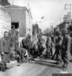 Des prisonniers allemands gardés par des soldats américains le long de la rue des Fossés Plissons à Domfront. Photo : US National Archives