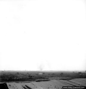 25 juillet 1944 : progression des troupes canadiennes au matin du lancement de l'opération Spring dans le secteur d'Ifs. Un camion de munitions a été touché et brûle. Photo : US National Archives