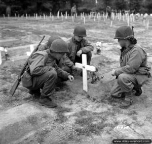24 juillet 1944 : des soldats américains se recueillent sur la tombe d’un camarade. Photo : US National Archives