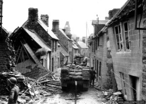 Une colonne de half-track M3 progresse le long de la rue Saint-Michel à Lonlay-l’Abbaye. Photo : US National Archives