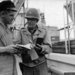 Photos of Port-en-Bessin in 1944 4 Discussion entre le Major E.D. Hill et Jack Williams concernant le déchargement du tanker visible sur la photo à Port-en-Bessin pour ravitailler les troupes alliées en carburant. Photo : US National Archives