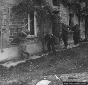 Des soldats américains de la 2nd (US) Infantry Division progressent lentement le long des maisons du bourg de Saint-Georges-d’Elle. Photo : US National Archives