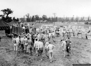 24 juillet 1944 : du personnel appartenant au service médical rassemble le matériel nécessaire pour l’hôpital de campagne de Saint-Hilaire-Petitville. Photo : US National Archives